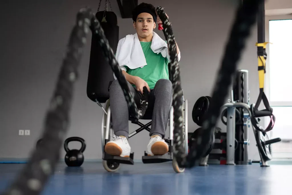 A disabled man sitting in his wheelchair doing exercise